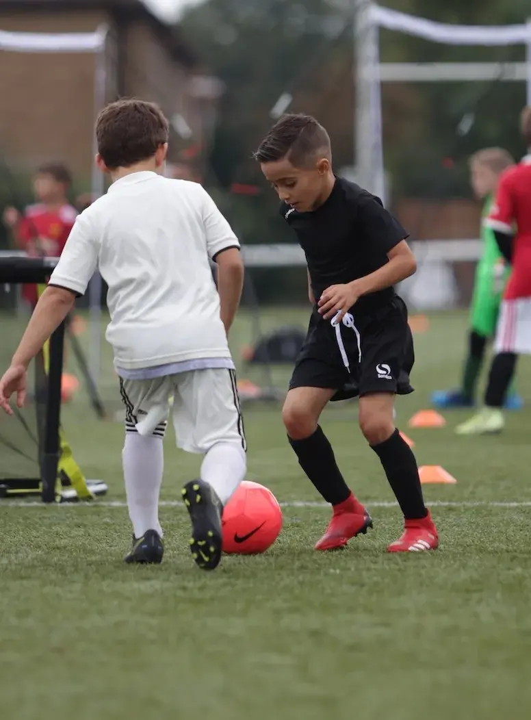 niños pequeños jugando al fútbol